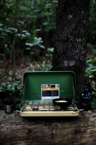 selective focus photography of camping stove on lug with cooked egg on pan photo