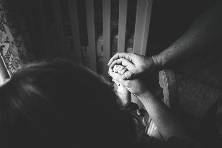 greyscale photo of person holding woman's hand photo