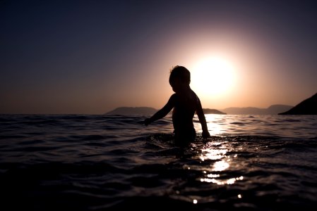 boy standing on body of water photo