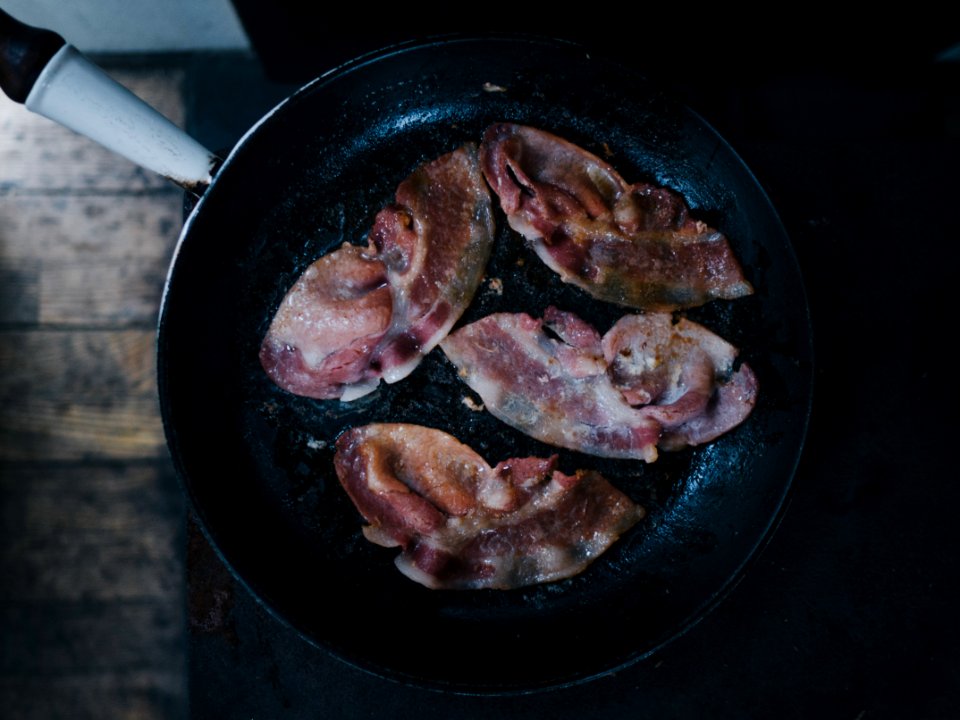bacon on top of black cast-iron skillet