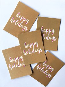 Brown paper with white writing that says "Happy Holidays."