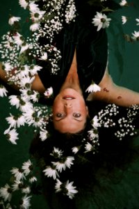woman swimming covered by white daisies photo