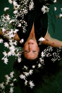 woman swimming covered by white daisies