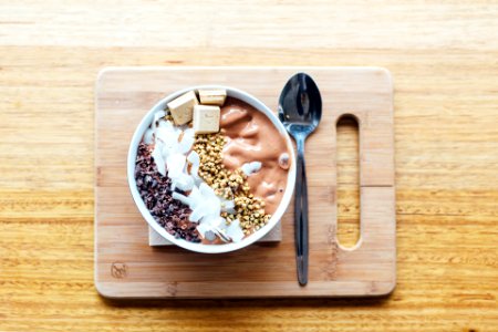 silver spoon and white bowl on brown wooden chopping board photo