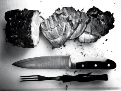 grayscale photo of grilled meat beside knife and fork photo
