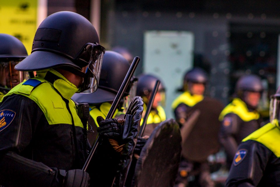 man in uniform holding baton and shield