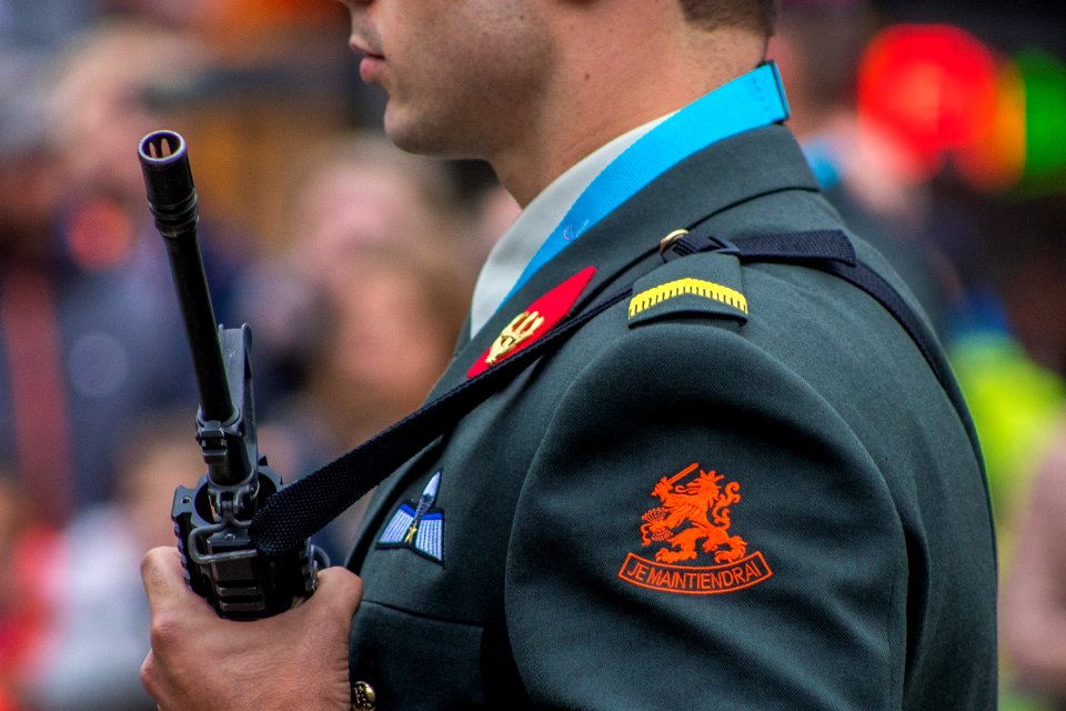 man holding rifle selective photography
