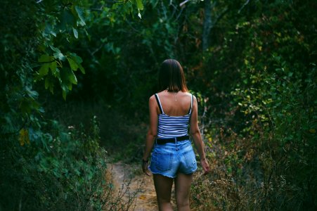 woman on pathway between trees photo