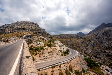 road near mountains under clouds photo