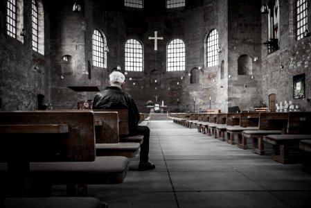 person sitting on pew inside church photo