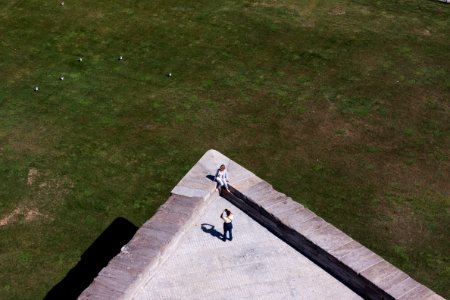 aerial photo of two person taking photo on top of building photo