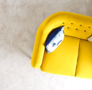 yellow fabric sofa with throw pillow photo