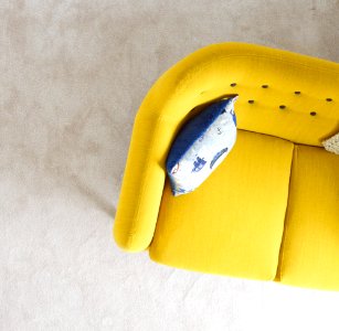 yellow fabric sofa with throw pillow