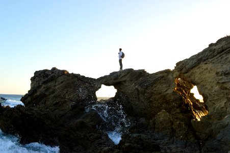 man standing on brown rock formations photo