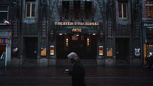 man standing near Theater Tuschinski building photo