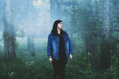 woman standing surrounded with trees photo