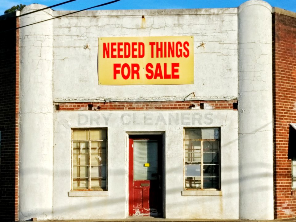needed things for sale poster posted on white concrete establishment