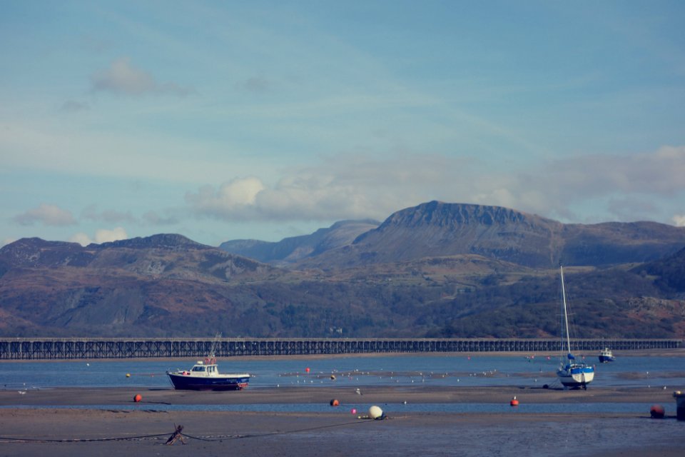 two white sailing boats near gray mountain