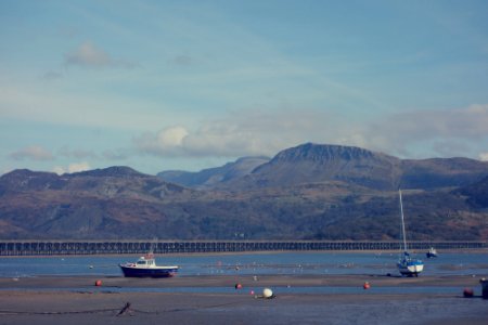two white sailing boats near gray mountain