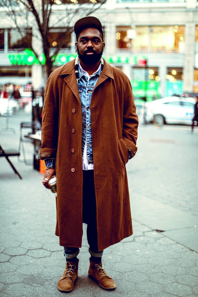 man standing on road near bare tree