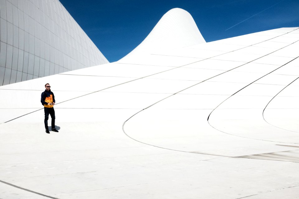 man in black and orange jacket under blue sky