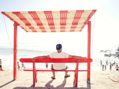 man sitting on bench near beach