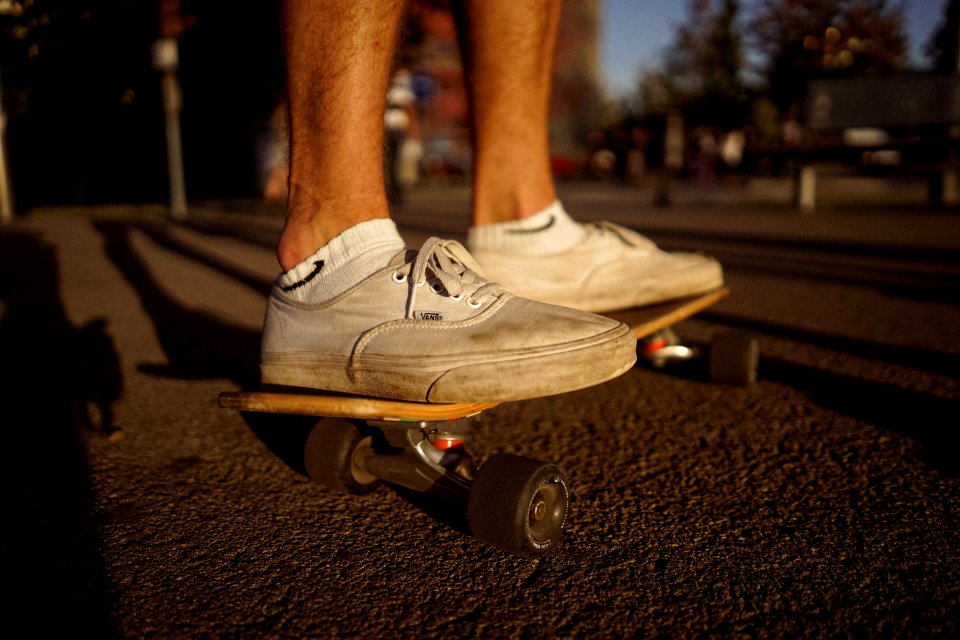 person on top of skateboard on gray pavement