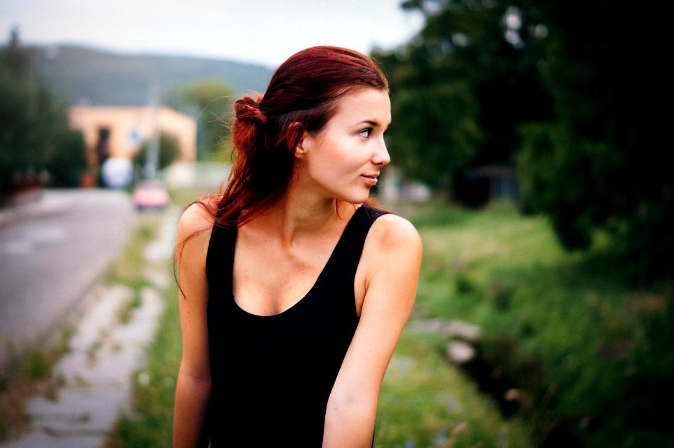 depth of field photography of woman in black tank top on street