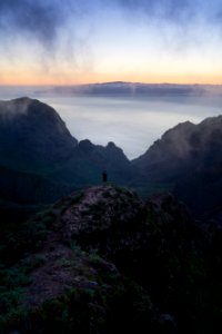 person standing on rock monolith