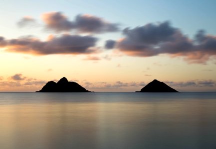 silhouette of two islands under cloudy sky photo
