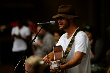 selective focus photography of man playing guitar and using microphone photo