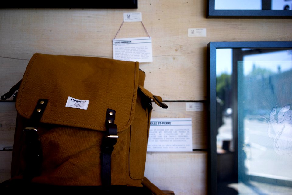 brown knapsack beside flat screen TV