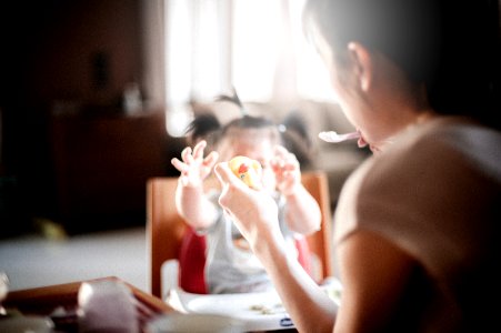 selective focus photography of woman feeding baby photo