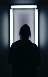 silhouette photo of person standing in front of mirror photo
