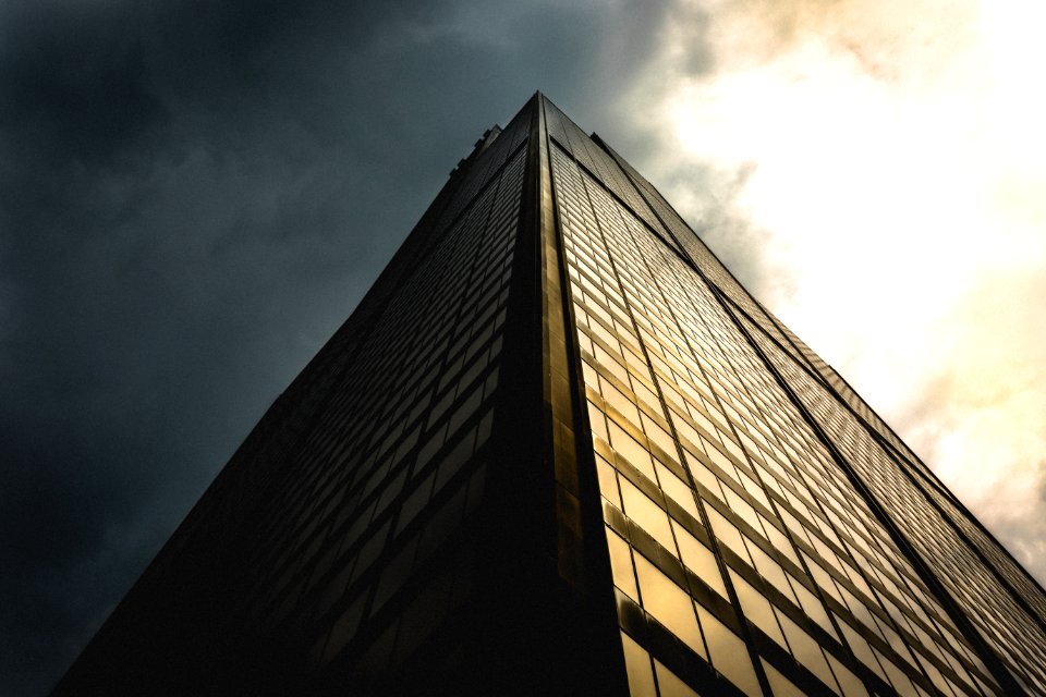 gray sky above black building low angle photography
