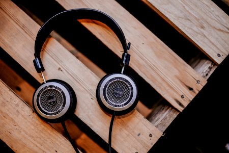 gray and black corded headphones on top of brown wooden surface