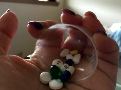 A little plastic ball full of tablet and capsule medication. photo