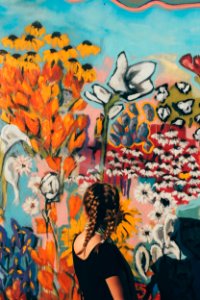 woman facing in front of floral graffiti wall photo
