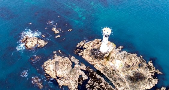 aerial photography of lighthouse near body of water photo