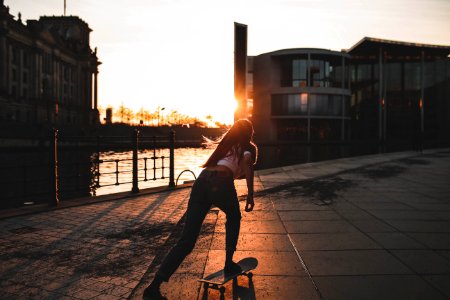woman playing skateboard near river during daytime photo