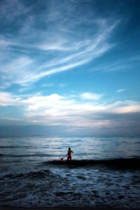 man standing on body of water holding paddle photo