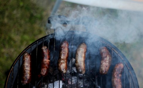 six sausages on black charcoal grill