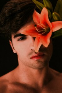 topless man with pink flower on ear photo