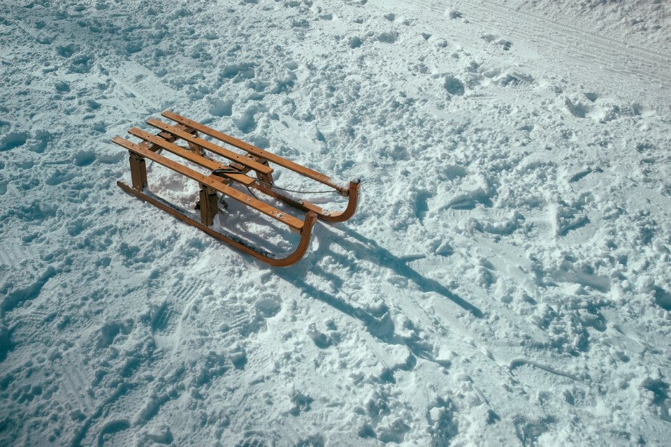 brown sled on snow during daytime