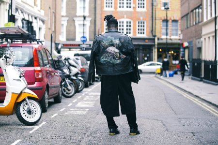 person wearing black jacket on road