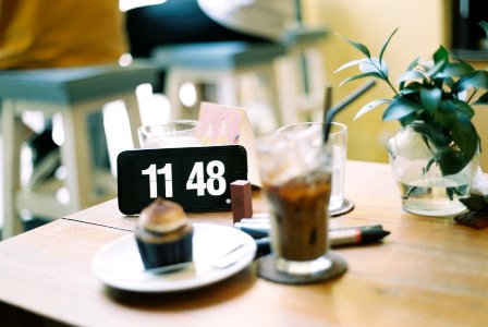 clear drinking glass beside round white ceramic plate on brown wooden table photo