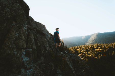 man standing on mountain cliff photo