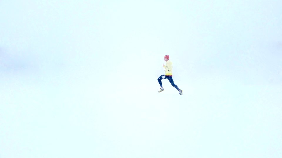 person wearing yellow jacket and black pants