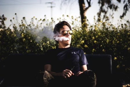 man sitting on bench and smoking photo