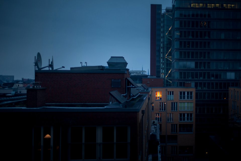 high rise buildings under gray clouds at nighttime